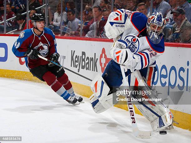 Goalie Richard Bachman of the Edmonton Oilers clears the puck away from Alex Tanguay of the Colorado Avalanche at Pepsi Center on March 30, 2015 in...