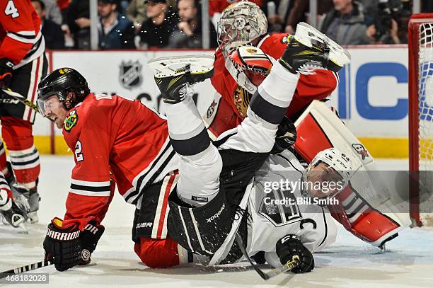 Dustin Brown of the Los Angeles Kings and Duncan Keith of the Chicago Blackhawks crash into goalie Scott Darling during the NHL game at the United...