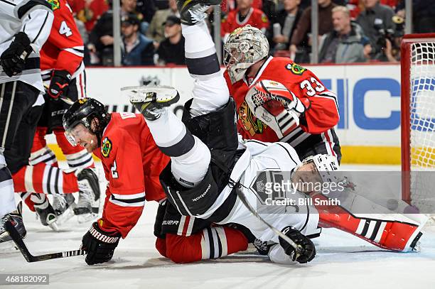 Dustin Brown of the Los Angeles Kings and Duncan Keith of the Chicago Blackhawks crash into goalie Scott Darling during the NHL game at the United...