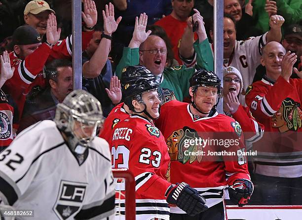 Fan cheer as Kris Versteeg, Jonathan Toews and Marian Hossa of the Chicago Blackhawks celebrate Hossa's third period goal against Jonathan Quick of...