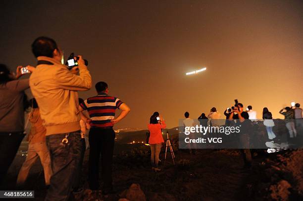 People take photos of solar-powered aircraft Solar Impulse 2 at Chongqing Jiangbei International Airport early Tuesday on March 31, 2015 in...