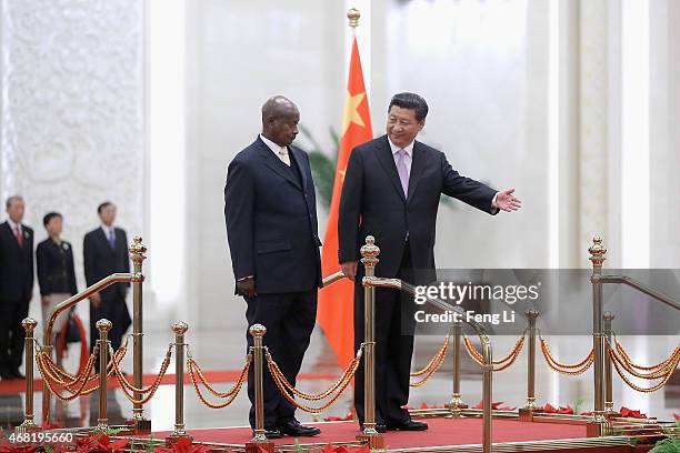 Chinese President Xi Jinping invites Ugandan President Yoweri Kaguta Museveni to view an honour guard during a welcoming ceremony inside the Great...