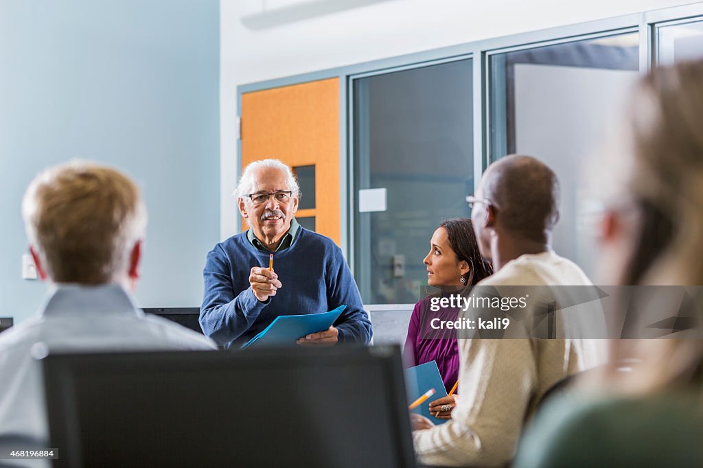 Senior Hispanic man teaching adult students