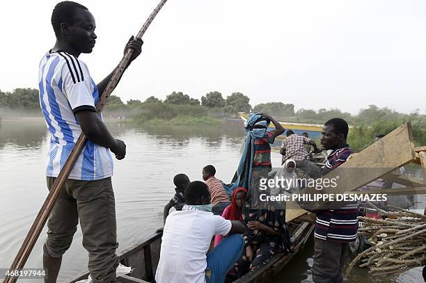 People wait in a boat to cross a section of Lake Chad on March 30, 2015 close to the village of Guite in Chad's lake region. AFP PHOTO/PHILIPPE...