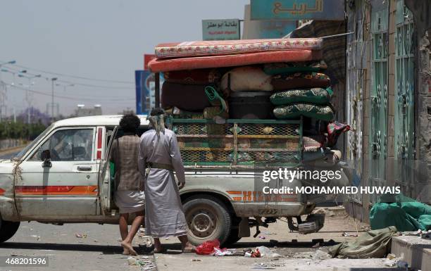 Yemenis pack their belongings into the back of a truck in Sanaa on March 31 as they flee the capital as Saudi-led coalition warplanes continue to...