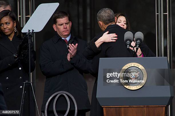 President Barack Obama hugs Victoria Reggie Kennedy as Boston Mayor Marty Walsh and First Lady Michelle Obama, look on, during a dedication ceremony...