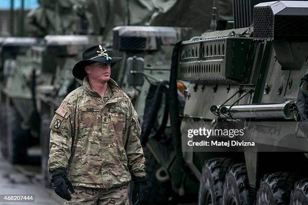 Soldier from the 3rd Squadron, 2nd Cavalry Regiment of the US Army walks past Stryker armored vehicles at the Czech army barracks on March 31, 2015...