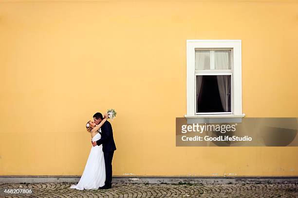 pareja de recién casados besando a la - newlywed fotografías e imágenes de stock