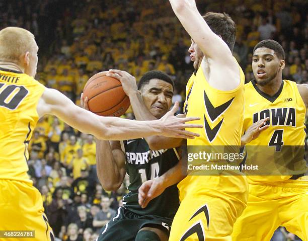 Guard Gary Harris of the Michigan State Spartans drives to the basket during the second half past between forwards Aaron White and Zach McCabe of the...