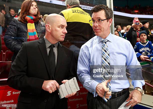 Assistant coach Mike Sullivan and video coach Darryl Williams of the Vancouver Canucks look on from the bench during their NHL game against the...