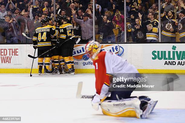 Teammates congratulate Milan Lucic of the Boston Bruins after he scored the game winning goal against Roberto Luongo of the Florida Panthers during...