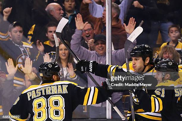 David Pastrnak and Ryan Spooner congratulate Milan Lucic of the Boston Bruins after he scored the game winning goal against the Florida Panthers...