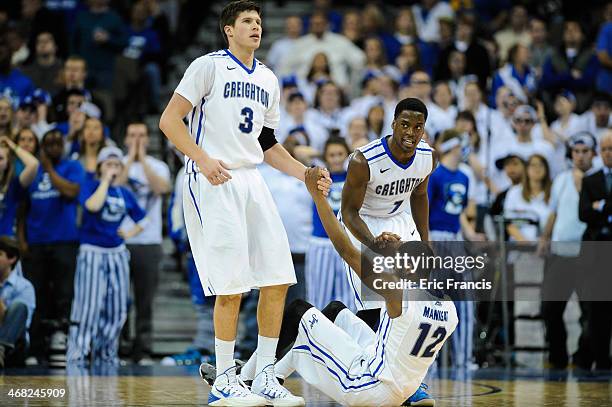 Doug McDermott and Austin Chatman of the Creighton Bluejays help teammate Jahenns Manigat during their game at CenturyLink Center on January 28, 2014...