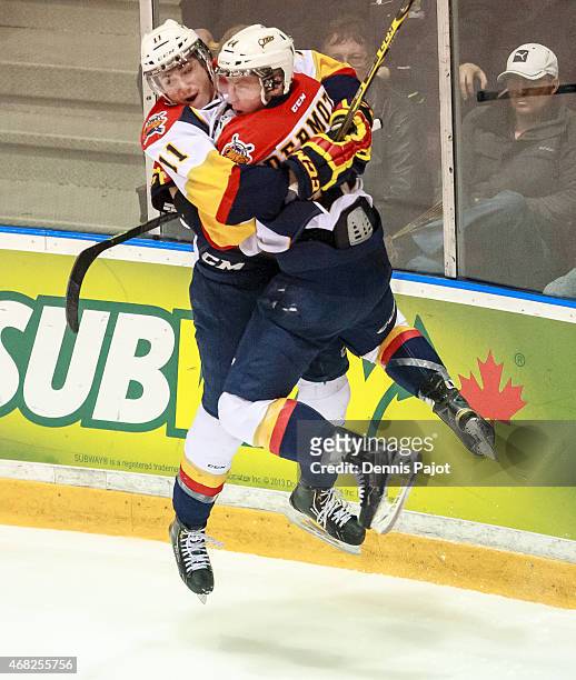 Defenceman Travis Dermott and forward Mason Marchment of the Erie Otters celebrate a goal against the Sarnia Sting during Game Four of the Western...