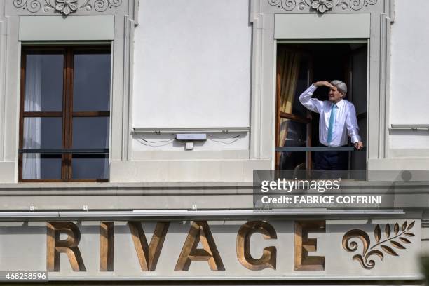 Secretary of State John Kerry looks out of the window of his room at the Beau-Rivage Palace hotel during a break in Iran nuclear talks in Lausanne,...