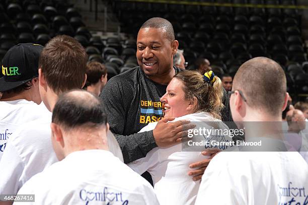 Head Coach Melvin Hunt of the Denver Nuggets hugs a participant during a basketball clinic for Special Olympics athletes from Colorado on March 26,...