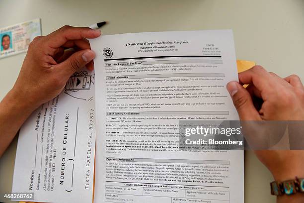 Juan Barbosa of Bakersfield, looks at a confirmation of petition acceptance for his application to the U.S. Citizenship and Immigration Services for...