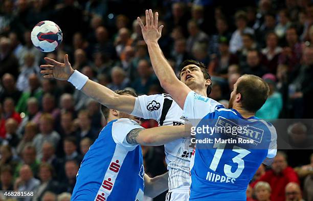 Rasmus Lauge Schimdt of Kiel challenges for the ball with Kristian Nippes of Bergischer HC during the DKB HBL Bundesliga match between THW Kiel and...
