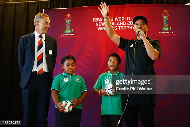 World Cup CEO Dave Beeche and New Zealand musician and NZ Idol Judge Stan Walker stand with school children Kazitoa Farani and Matilda Lako after...