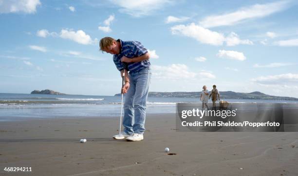 Irish golfer Philip Walton putting on Malahide Beach in Ireland, circa 1995.