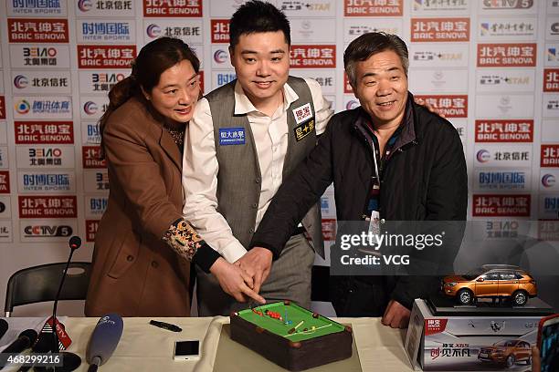 Ding Junhui of China celebrate his 28th birthday with his parents after winning the second round match against Steve Davis of England on day three of...