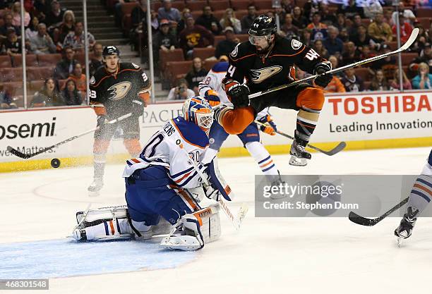 Nate Thompson of the Anaheim Ducks jumps in the air as a shot by Duck Francois Beauchemin gets by goalie Ben Scrivens of the Edmonton Oilers for a...