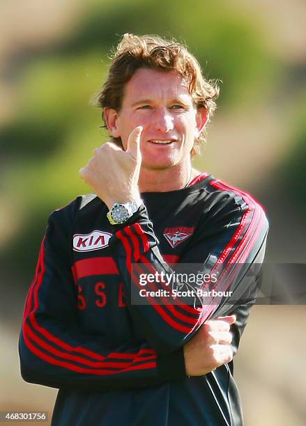 James Hird, coach of the Bombers gives a thumbs up gesture to supporters in the crowd as they applaud as the Bombers come out to begin training...
