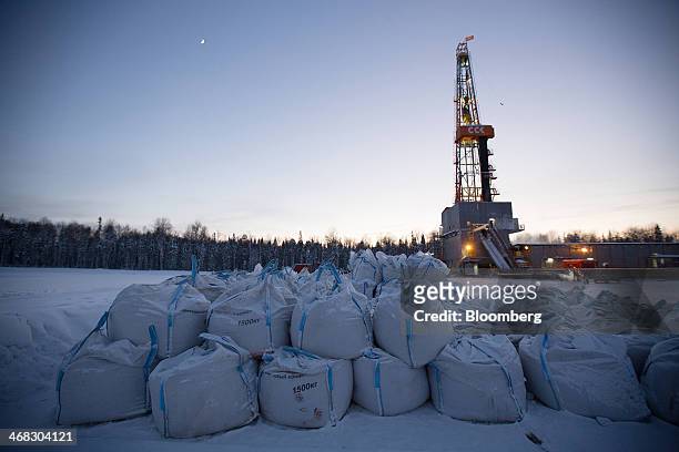Sacks of barite concentrate sit near an oil derrick in the Salym Petroleum Development oil fields near the Bazhenov shale formation in Salym, Russia,...