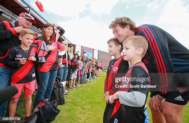 James Hird, coach of the Bombers poses for photographs with supporters in the crowd who turned up to watch training after an Essendon Bombers AFL...