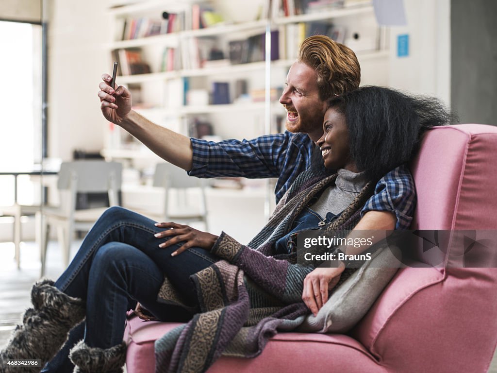 Cheerful couple taking a selfie with mobile phone.