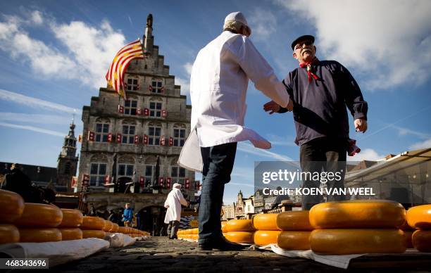 An Inspector speaks with a Cheesemaker at a market at the opening of the Dutch Cheese season in Gouda on April 2, 2015. AFP PHOTO / ANP/ KOEN VAN...