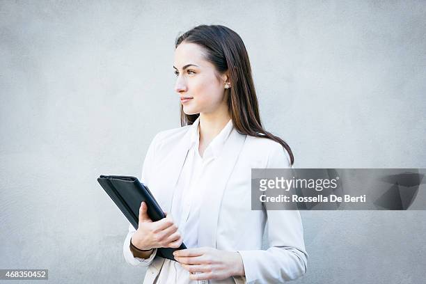 smiling businesswoman leaning against wall portrait - smart casual stock pictures, royalty-free photos & images