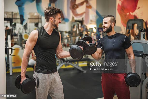 two muscular build men having weight training in a gym. - male friendship stock pictures, royalty-free photos & images