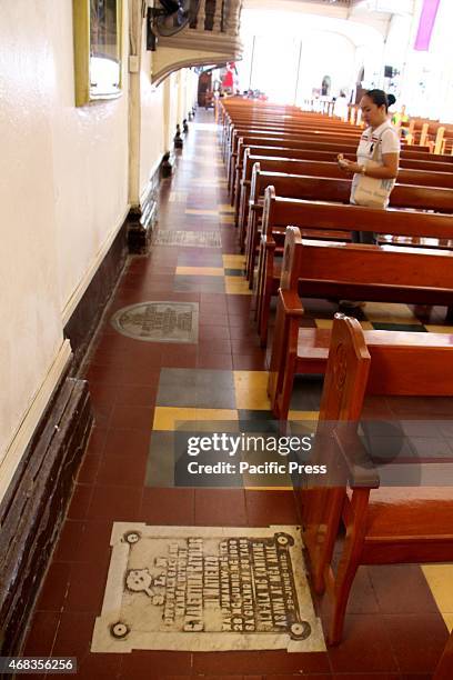 Devotee taking prayer in front of station of the cross inside of san Ildefonso De Toledo Parish Church in Tanay, Rizal with a grave stone on the...