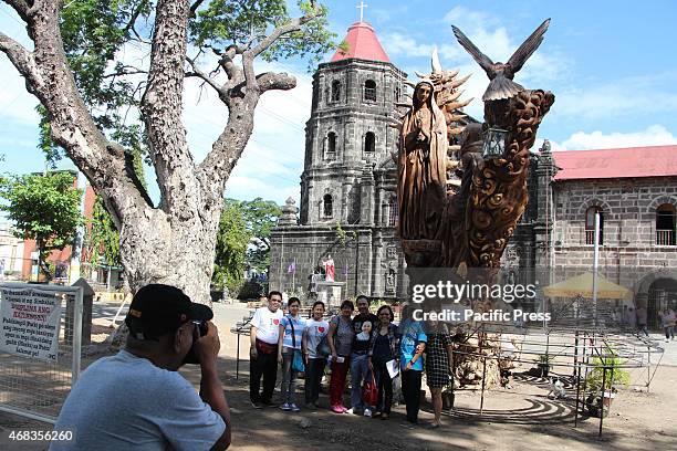 Group of catholic devotees taking a picture in front of statue of Saint Maria of Guadalupe with San Ildefonso De Toledo entitled Pamana ng Tanay...