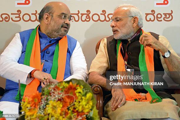 Indian Bharatiya Janata Party national president Amit Shah and Prime Minister Narendra Modi talk during a BJP office bearers' meeting held on the eve...
