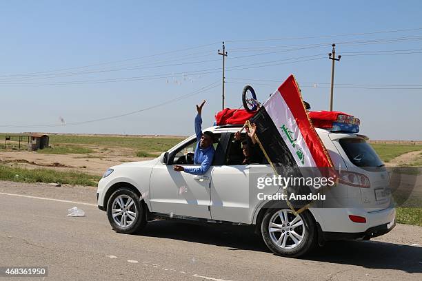 Iraqis cheer up as they wait at a checkpoint to arrive Tikrit after Iraqi forces, including soldiers, police officers, Shiite militias and Sunni...