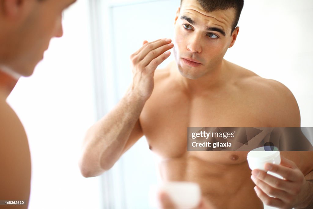 Man applying moisturizer.