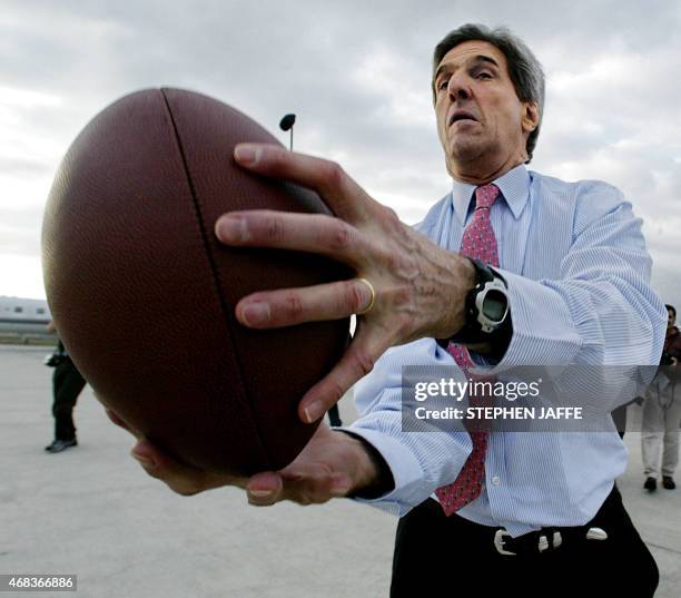 Democratic presidential candidate Senator John Kerry plays football on the tarmac of Hartsfield Airport 02 March 2004 in Atlanta, Georgia. Kerry has...