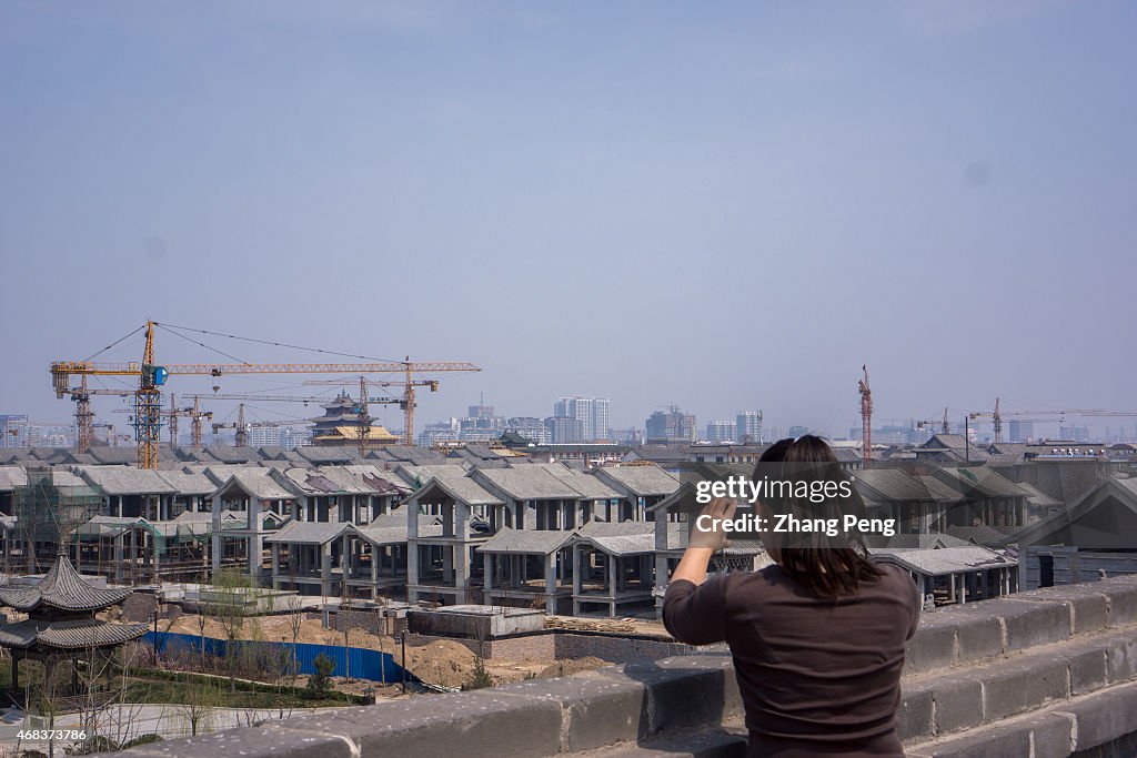 A tourist is taking photos of a huge construction site on...