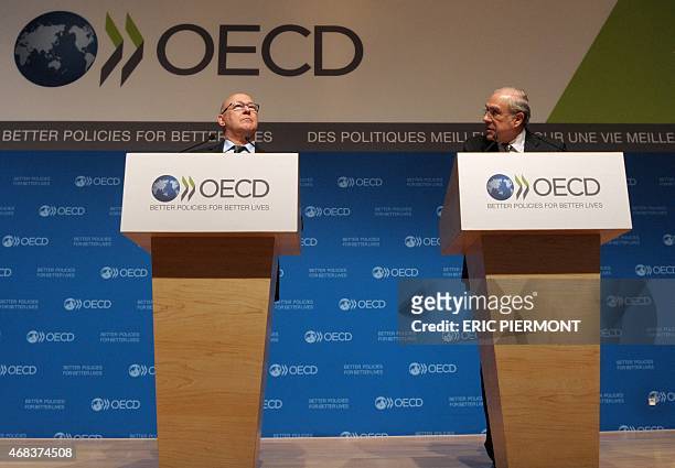 Secretary General Angel Gurria and French Finance Minister Michel Sapin address a press conference for the launching of the OECD economic survey of...