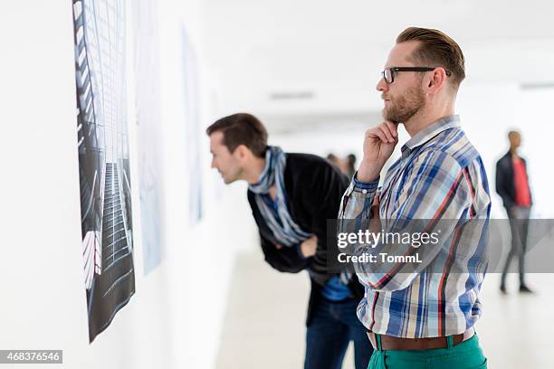 visitantes olhando para gráficos - gallery opening imagens e fotografias de stock