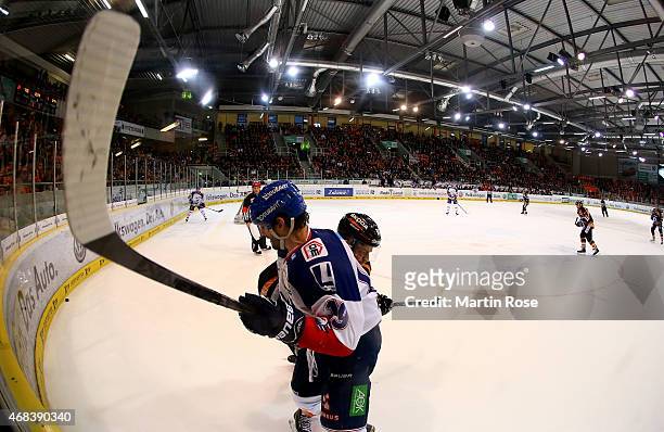 Aleksander Polaczek of Wolfsburg and Daniel Richmond of Mannheim battle for the puck in game four of the DEL semi final play-offs between Grizzly...