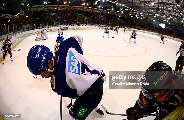 Christian Neuert of Wolfsburg and Sinan Akdag of Mannheim battle for the puck in game four of the DEL semi final play-offs between Grizzly Adams...