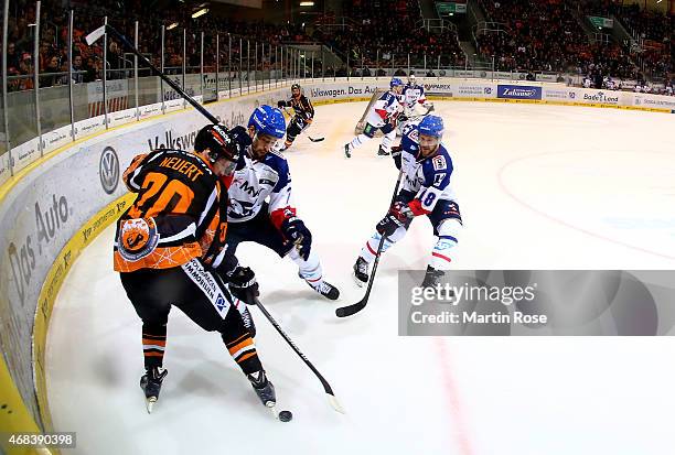 Christian Neuert of Wolfsburg and Sinan Akdag of Mannheim battle for the puck in game four of the DEL semi final play-offs between Grizzly Adams...