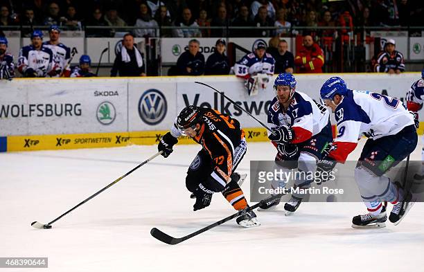 Sergej Stas of Wolfsburg and Nicolai Goc of Mannheim battle for the puck in game four of the DEL semi final play-offs between Grizzly Adams Wolfsburg...