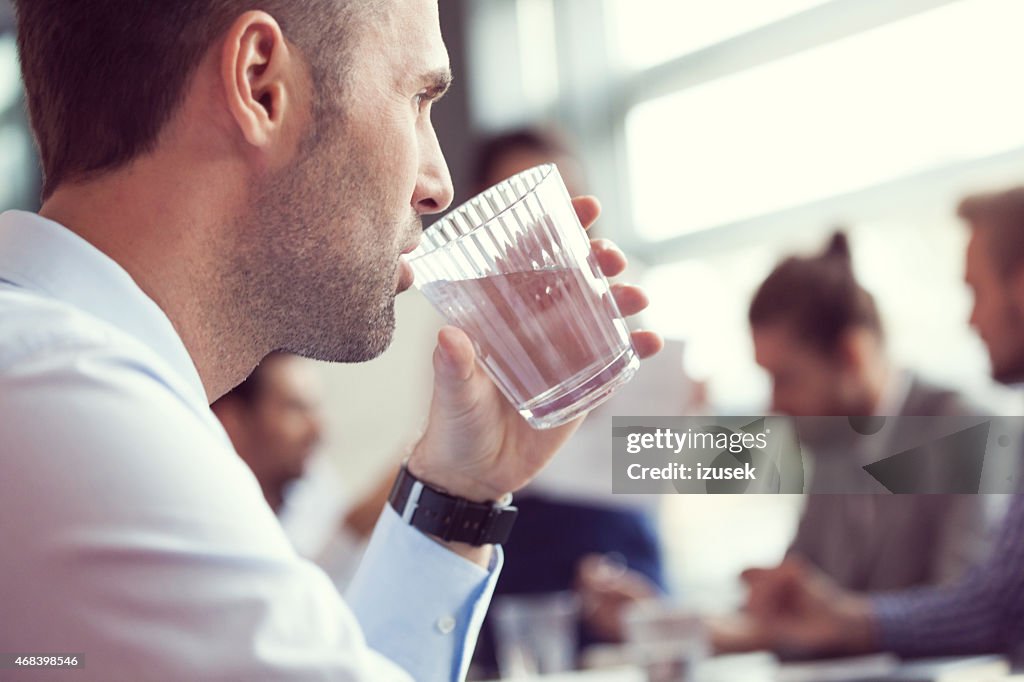 Businessman drinking water at the meeting