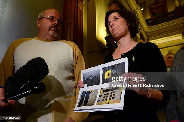 Jane Dougherty, right, who's sister Mary Sherlach was killed at Sandy Hook elementary school, holds up a photocopy showing the AR-15 semi-automatic...