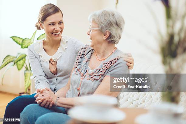 young social worker is visiting a senior woman at home - healthcare worker beauty in nature stock pictures, royalty-free photos & images