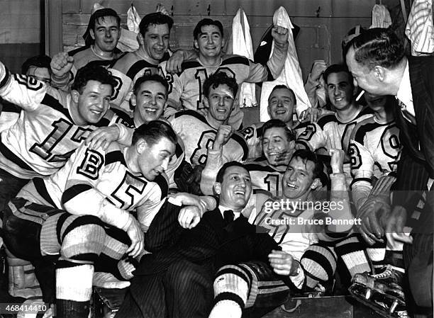 The Boston Bruins celebrate in the locker room with coach Cooney Weiland and general manager Art Ross after Game 4 of the 1941 Stanley Cup Finals...